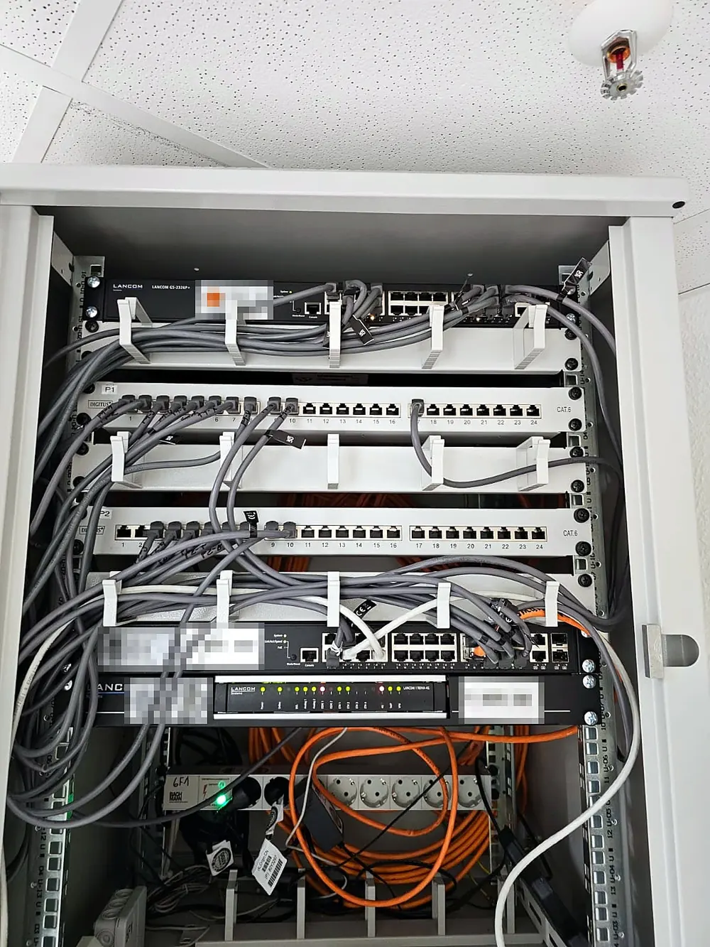 Patchfeld mit sortierten grauen Patchkabeln über zwei Switches